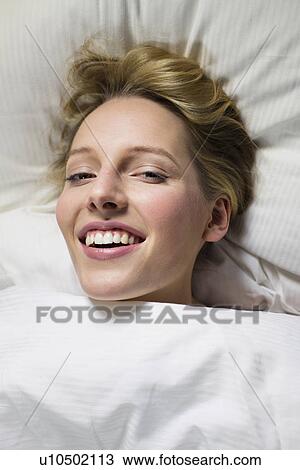 Young woman under duvet, head on pillow View Large Photo Image Stock Image - Young woman under duvet, head on pillow. Fotosearch