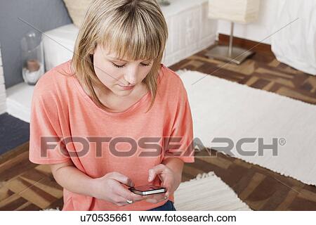 Stock Image - Young woman using cellular phone. Fotosearch