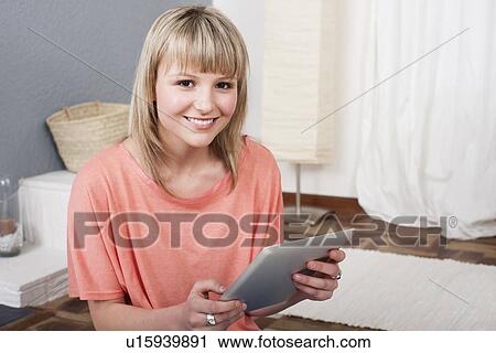 Young woman using digital tablet View Large Photo Image Stock Image - Young woman using digital tablet. Fotosearch