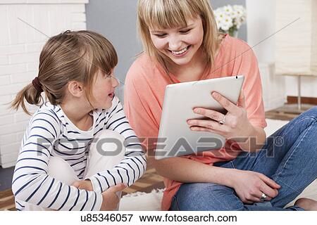 Stock Photo - Young woman using digital tablet. Fotosearch