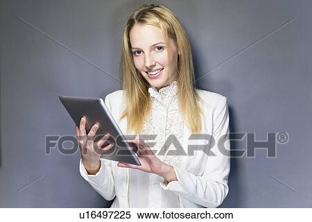 Stock Photography - Young woman using digital tablet. Fotosearch