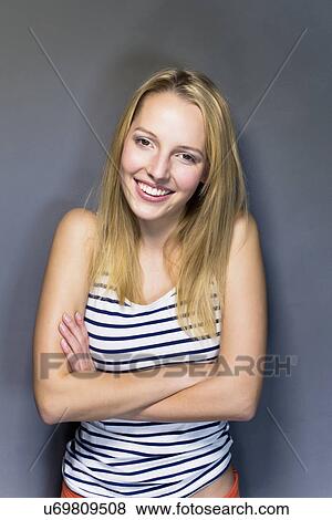 Young woman wearing striped vest with arms crossed View Large Photo Image Stock Photo - Young woman wearing striped vest with arms crossed. Fotosearch