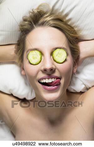 Young woman with cucumber slices covering eyes View Large Photo Image Stock Image - Young woman with cucumber slices covering eyes. Fotosearch