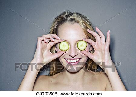 Young woman with cucumber slices covering eyes View Large Photo Image Stock Photo - Young woman with cucumber slices covering eyes. Fotosearch