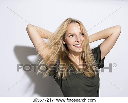 Young Woman With Long Blonde Hair Hands Behind Head Stock Photo