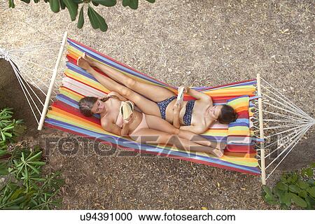 Young women lying on hammock reading View Large Photo Image Stock Image - Young women lying on hammock reading. Fotosearch