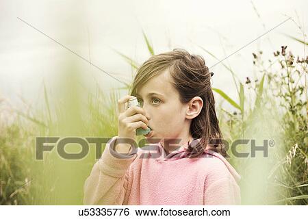 Anxious girl using an inhaler outdoors View Large Photo Image Stock Photograph - Anxious girl using an inhaler outdoors. Fotosearch