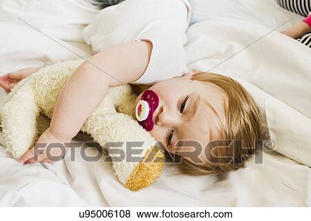 Stock Photo - Baby girl asleep with teddy bear. Fotosearch