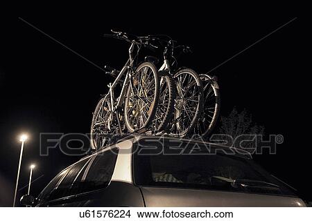 Bikes on roof rack of car at night View Large Photo Image Picture - Bikes on roof rack of car at night. Fotosearch