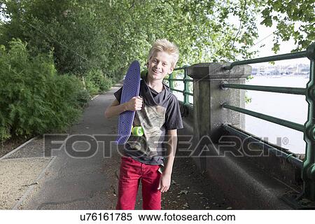 Stock Photography - Boy carrying skateboard. Fotosearch
