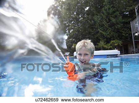 Boy in swimming pool squirting water gun View Large Photo Image Stock Photo - Boy in swimming pool squirting water gun. Fotosearch