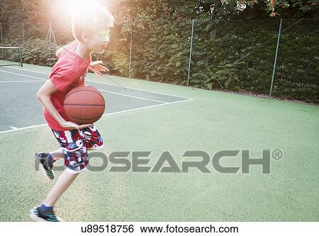 Stock Photograph - Boy playing basketball. Fotosearch