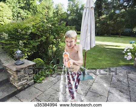 Picture - Boy squirting hose. Fotosearch