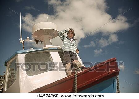 Boy standing on front of boat View Large Photo Image Stock Image - Boy standing on front of boat. Fotosearch