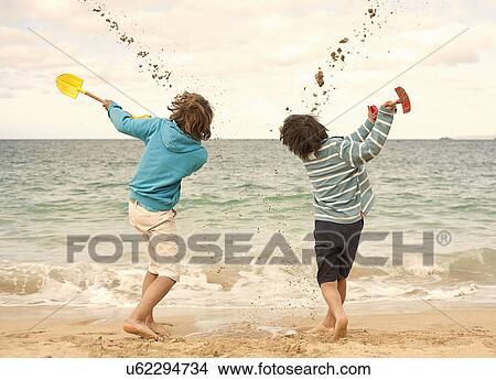 Boys digging sand with spades View Large Photo Image Picture - Boys digging sand with spades. Fotosearch