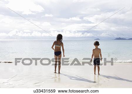 Stock Photo - Brother and sister looking out to sea. Fotosearch