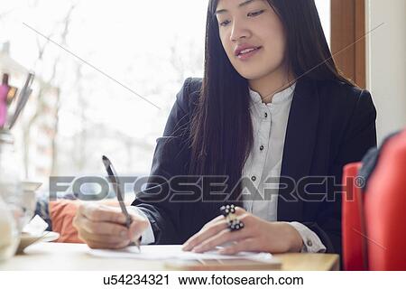 Stock Image - Business woman writing. Fotosearch