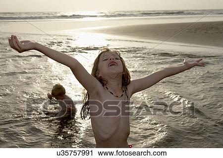 Stock Image - Children playing in sea. Fotosearch