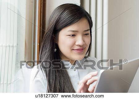 Stock Photo - Close up of woman using digital tablet. Fotosearch