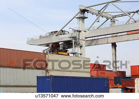 Stock Photo - Container crane and stacks of freight containers in port. Fotosearch