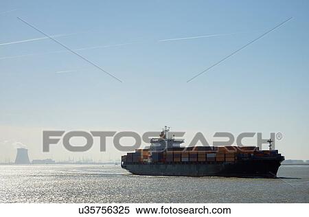 Stock Photography - Container ship leaving Antwerp harbor, Belgium. Fotosearch