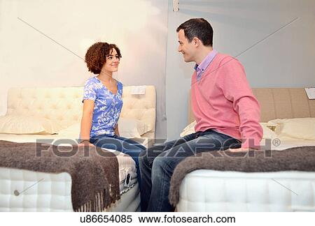 Couple sitting on beds in furniture shop showroom View Large Photo Image Stock Photography - Couple sitting on beds in furniture shop showroom. Fotosearch