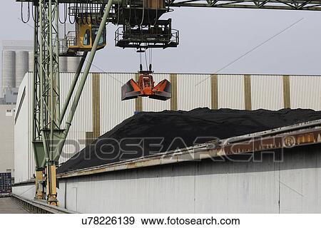 Stock Photo - Crane grab and pile of coal in port. Fotosearch