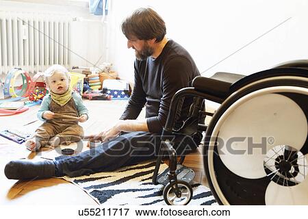 Disabled father with son playing on floor View Large Photo Image Stock Photo - Disabled father with son playing on floor. Fotosearch