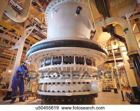 Stock Photo - Engineer adjusting seawater valve in power. Fotosearch