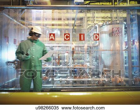 Stock Photography - Engineer reading notes in acid store in power station. Fotosearch
