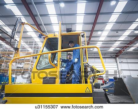 Engineers in cab of tow truck in truck repair factory View Large Photo Image Stock Photo - Engineers in cab of tow truck in truck repair factory. Fotosearch