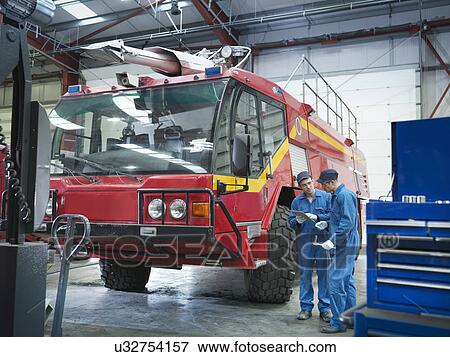 Engineers with fire engine in truck repair factory View Large Photo Image Stock Photo - Engineers with fire engine in truck repair factory. Fotosearch