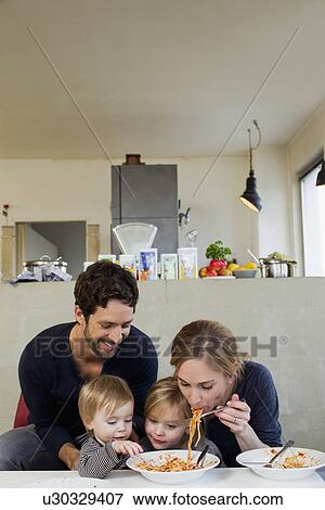Family with two daughters eating spaghetti meal View Large Photo Image Stock Photo - Family with two daughters eating spaghetti meal. Fotosearch