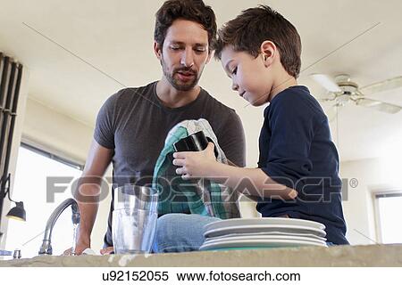 Stock Photography - Father and son doing washing up chores. Fotosearch