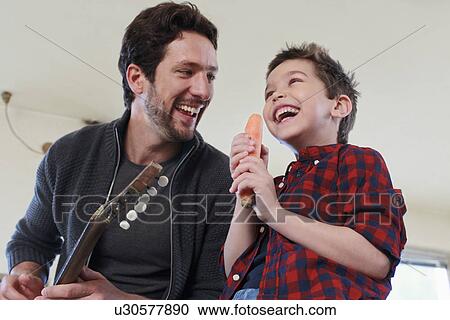 Father and son with guitar and carrot microphone View Large Photo Image Stock Image - Father and son with guitar and carrot microphone. Fotosearch