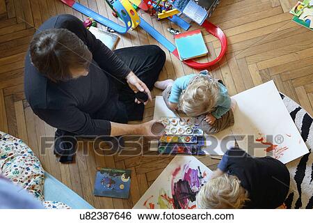 Father and sons painting on floor View Large Photo Image Stock Photograph - Father and sons painting on floor. Fotosearch