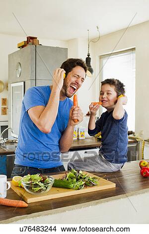 Father and young son singing into carrot microphones View Large Photo Image Picture - Father and young son singing into carrot microphones. Fotosearch