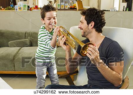 Father encouraging young son playing trumpet View Large Photo Image Stock Image - Father encouraging young son playing trumpet. Fotosearch