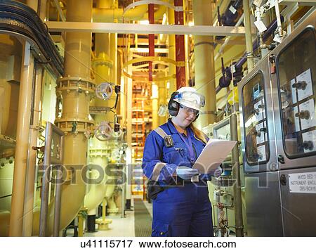 Stock Photo - Female chemist reading notes in plant in power station. Fotosearch