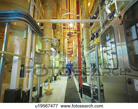 Female chemist walking amongst the pipework in power station View Large Photo Image Stock Photo - Female chemist walking amongst the pipework in power station. Fotosearch