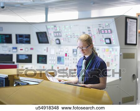 Stock Photo - Female operator reading notes in nuclear power station control room simulator. Fotosearch