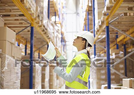 Female warehouse worker checking stock View Large Photo Image Stock Photography - Female warehouse worker checking stock. Fotosearch