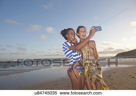 Friends on beach taking self portrait photograph View Large Photo Image Stock Photography - Friends on beach taking self portrait photograph. Fotosearch