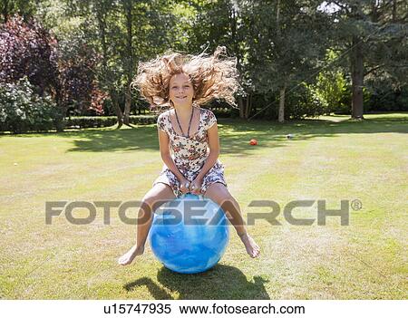 Stock Photography - Girl jumping on space hopper. Fotosearch