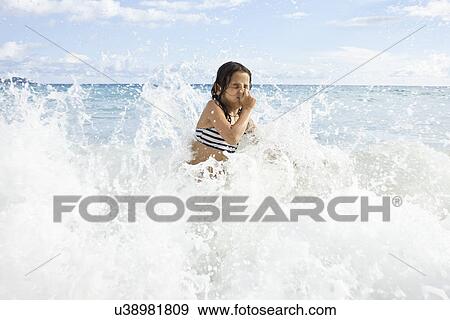Girl playing in sea, holding nose View Large Photo Image Stock Photo - Girl playing in sea, holding nose. Fotosearch