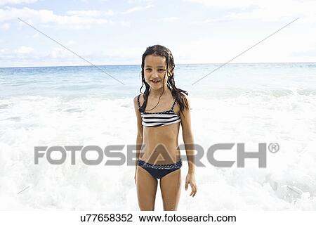 Girl playing in sea, looking at camera View Large Photo Image Stock Image - Girl playing in sea, looking at camera. Fotosearch