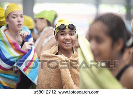 Stock Image - Group of schoolgirls wrapped in towels after swimming. Fotosearch