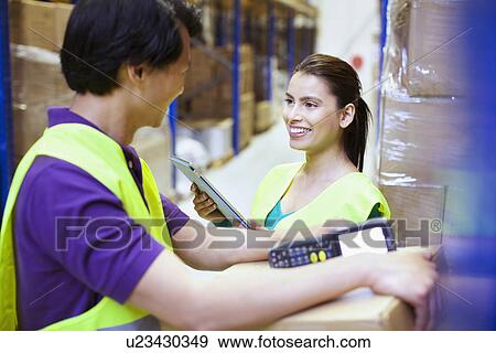 Male and female workers chatting in distribution warehouse View Large Photo Image Stock Photo - Male and female workers chatting in distribution warehouse. Fotosearch