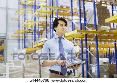 Male manager using digital tablet in distribution warehouse View Large Photo Image Stock Photograph - Male manager using digital tablet in distribution warehouse. Fotosearch