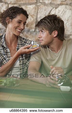 Man and woman sitting around table, tasting drinks View Large Photo Image Stock Photography - Man and woman sitting around table, tasting drinks. Fotosearch